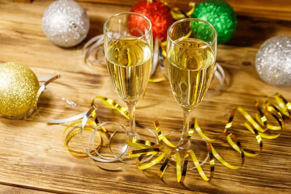 stock image Two glasses of champagne and festive Christmas decorations on wooden table. Christmas and New Year celebration