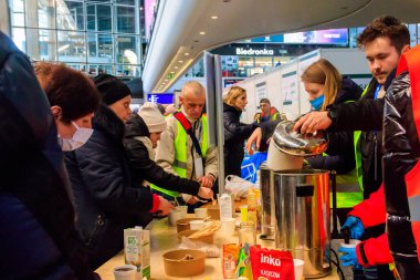 Varşova, Polonya - 9 Mart 2022: Gönüllüler Polonya 'nın Varşova kentindeki tren istasyonunda Ukraynalı mültecilere yardım ediyor