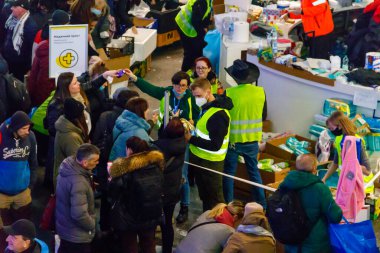 Varşova, Polonya - 9 Mart 2022: Gönüllüler Polonya 'nın Varşova kentindeki tren istasyonunda Ukraynalı mültecilere yardım ediyor