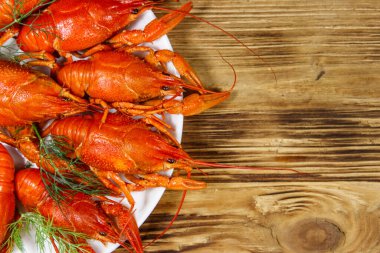 Ahşap masada kaynamış kerevit tabağı. Üst görünüm