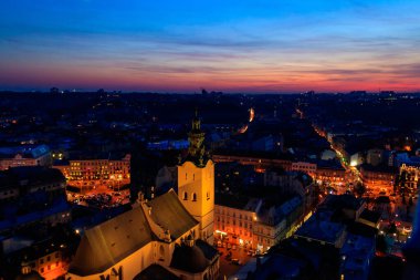Ukrayna, Lviv 'deki Aydınlatılmış Latin Katedrali ve Rynok Meydanı' nın gece görüşü. Lviv belediye binasından görüntü