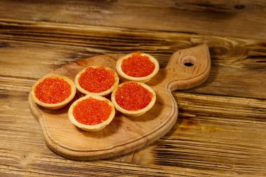 Tahta bir masada kırmızı havyarlı turta.