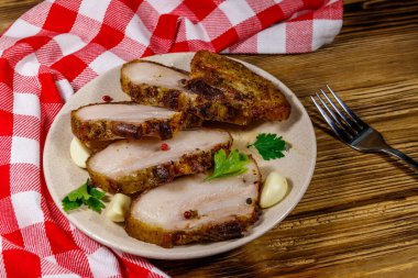 Ahşap bir masada pişmiş domuz göbeği.