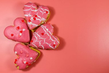 Pembe arka planda kalp şeklinde kurabiyeler. Üst görünüm, boşluğu kopyala. Sevgililer Günü için tatlı