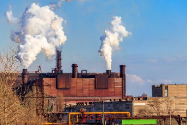 Dumanlı boruları olan eski bir fabrika manzarası. Hava kirliliği, çevresel hasar