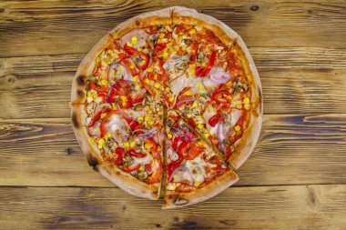 Tahta bir masada nefis taze pizza. Üst görünüm