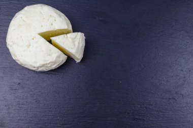 Siyah arkaplandaki yumuşak Adighe peyniri. Üst görünüm