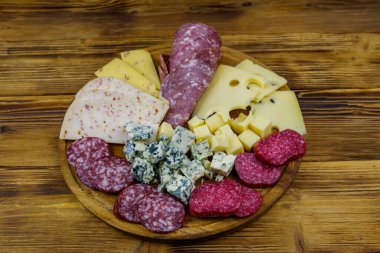 Tahta masada İtalyan salam ve peynirinden oluşan antipasti tabağı.