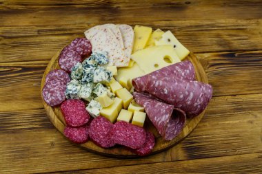 Tahta masada İtalyan salam ve peynirinden oluşan antipasti tabağı.