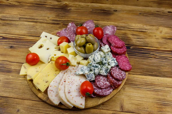 Antipasti platter with olives, cherry tomatoes, assortment of italian salami and cheese on a wooden table