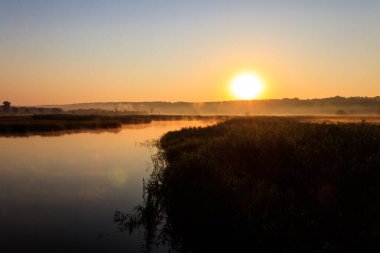Gün doğumunda sisli nehir manzarası. Sabaha karşı sisli
