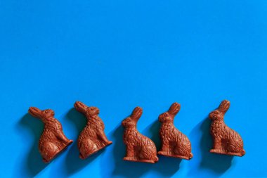 Mavi arka planda Paskalya çikolatalı tavşanları. Üst görünüm