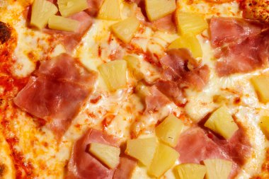 Texture of a delicious fresh hawaiian pizza with sausage, pineapple and cheese