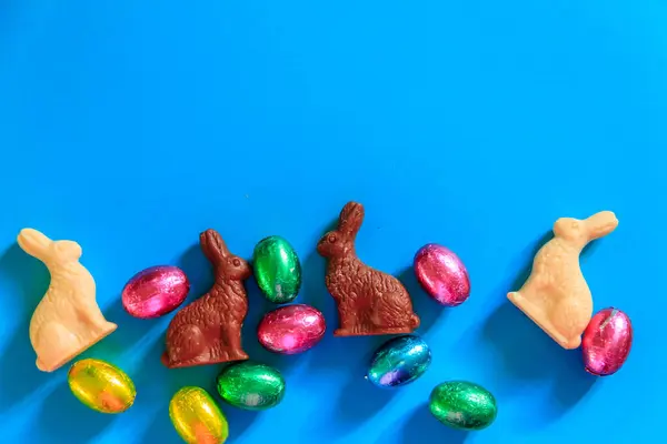 Osterschokoladeneier Folie Und Osterhasen Auf Blauem Hintergrund Ansicht Von Oben — Stockfoto