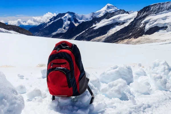 スイスアルプスの山々を背景に雪の上の観光バックパック アウトドアのコンセプトを旅行 — ストック写真