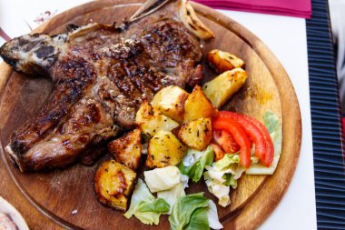 Kızarmış domuz bifteği, patates ve sebzeli kemik.