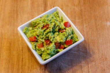 Tahta bir masada bir kase guacamole.