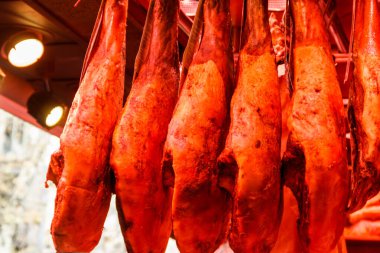 Jamon Serrano jambon bacakları geleneksel bir İspanyol pazarında sallanıyor.