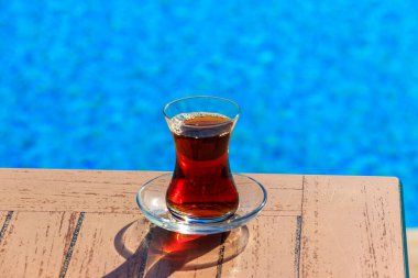 Yüzme havuzunun yanındaki masada sıcak Türk çayı