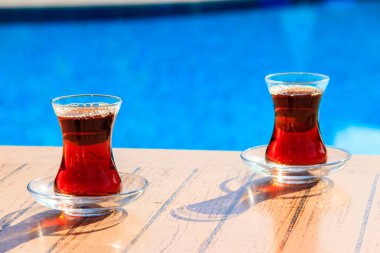 Yüzme havuzunun yanındaki masada sıcak Türk çayı