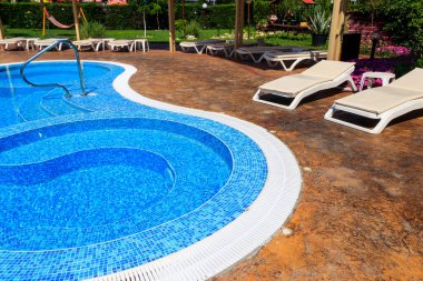 Tropik bir tatil köyünde temiz suyla yüzme havuzu.