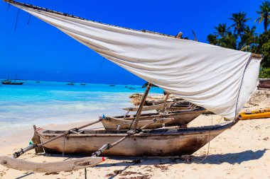 Geleneksel ahşap dhow tekneleri Hint Okyanusu 'nun Zanzibar, Tanzanya' daki tropikal kumlu sahillerinde kıyıya vurur.