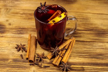 Ahşap masada sıcak şarap ve baharatlar.