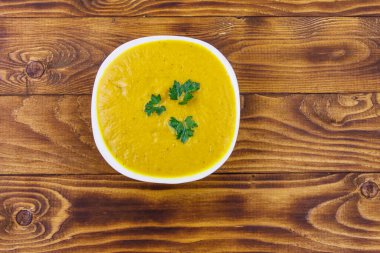 Ahşap bir masada balkabağı çorbası. Üst görünüm