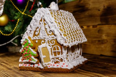 Noel zencefilli kurabiye evi ahşap bir masanın üstünde.