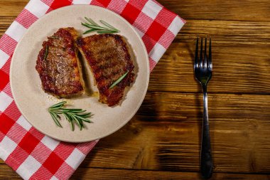 Ahşap masada ızgara domuz bifteği ve biberiye. Üst görünüm