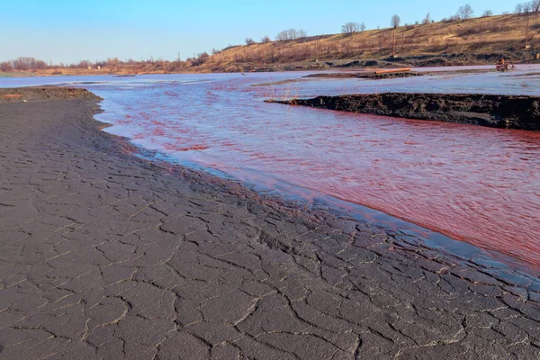 Technical settler of industrial water of mining industry in Kryvyi Rih, Ukraine. Red water polluted with iron ore waste. Discharge of process water in the sump after the iron ore beneficiation