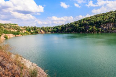 Yazın terk edilmiş taş ocağında göl manzarası