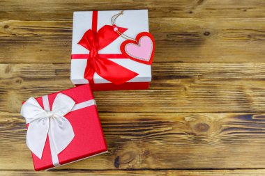 Ahşap arka planda hediye kutuları ve kırmızı kalp. Sevgililer Günü konsepti