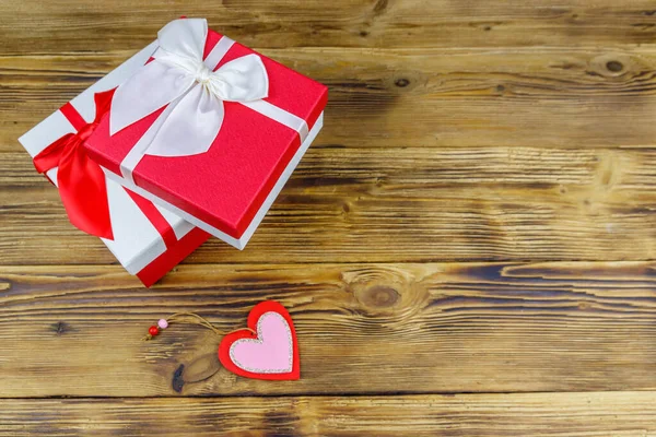 Ahşap arka planda hediye kutuları ve kırmızı kalp. Sevgililer Günü konsepti