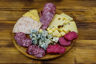 Tahta masada İtalyan salam ve peynirinden oluşan antipasti tabağı.