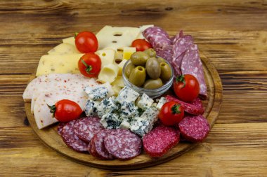 Zeytinli, kiraz domatesli, ahşap bir masada İtalyan salamı ve peyniri karışımı.