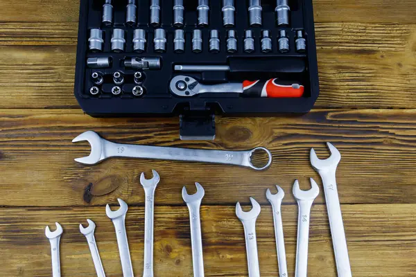 Universal tool kit for car repair and set of wrench tools on wooden background. Top view