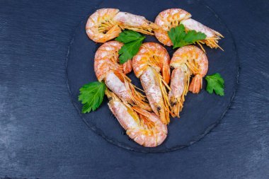 Boiled large langoustines on a black slate. Top view