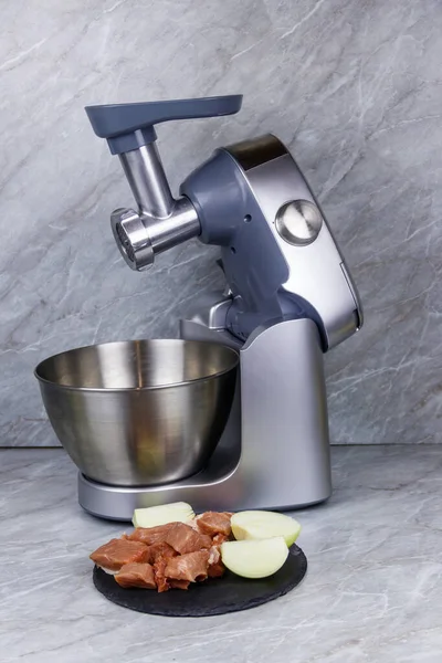 Electric eat grinder and fresh meat on kitchen table. Preparation of minced meat