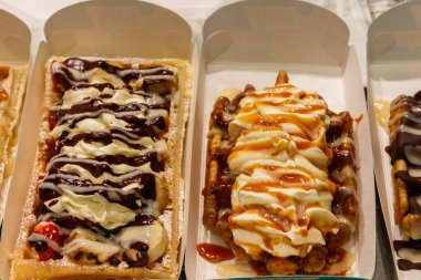 Brüksel, Belçika 'da renkli tatlı soslu Belçika waffleları ve satılık meyveler