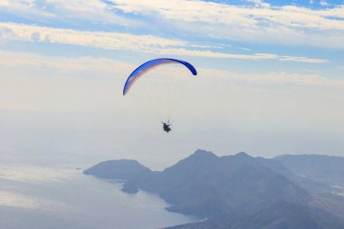 Türkiye 'nin Antalya ilinin Kemer ilçesi yakınlarındaki Tahtali dağının tepesinden paraşütçüler uçuyor. Aktif yaşam tarzı ve ekstrem spor macerası kavramı