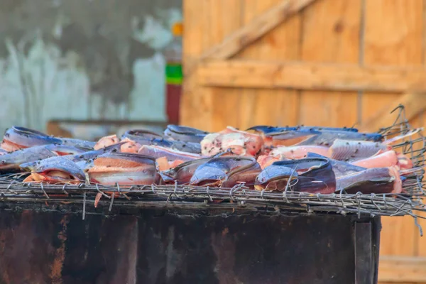 Fish cooking for sale at a local street food market in Tanzania