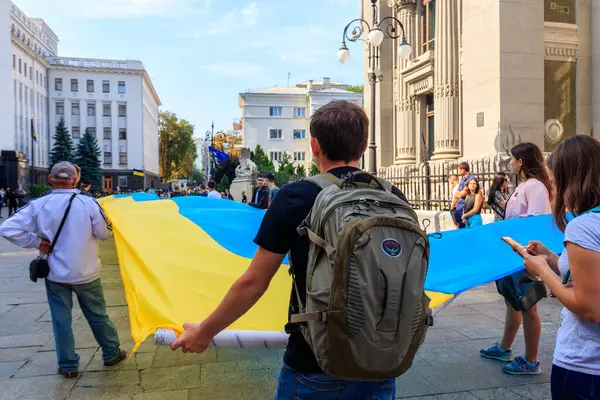 Kiev, Ukrayna - 23 Ağustos 2019: Ukrayna 'nın Kiev kentinde düzenlenen Ukrayna Bayrağı Günü sırasında başkanlık yönetimi yakınlarında büyük bir Ukrayna bayrağı taşıyan insanlar