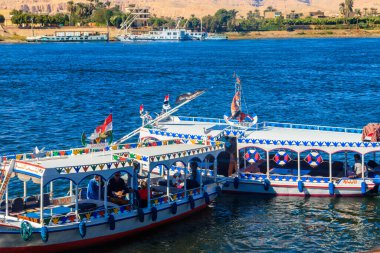 Luxor, Egypt - December 11, 2018: Tourist boats moored near the shore of Nile river in Luxor, Egypt