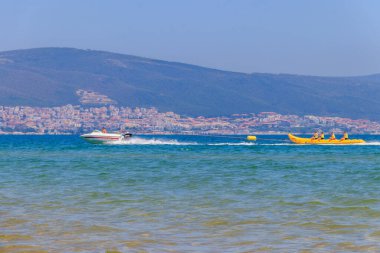 Sunny Beach, Bulgaristan - 29 Haziran 2021: Bulgaristan 'ın Sunny Beach kentindeki Karadeniz' de bir sürat teknesinde insanların çektiği şişirilebilir muz teknesi