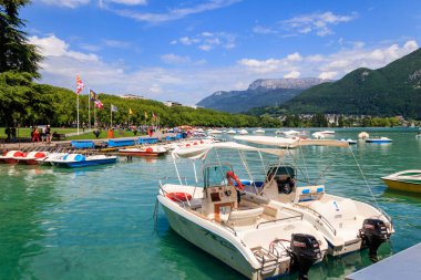 Annecy, Fransa - 16 Mayıs 2022: Annecy Gölü 'ndeki botlar ve pedallar Fransa' nın Annecy kentindeki güzel dağlarla çevrili