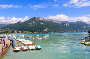 Annecy, Fransa - 16 Mayıs 2022: Annecy Gölü 'ndeki botlar ve pedallar Fransa' nın Annecy kentindeki güzel dağlarla çevrili