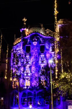 Barcelona, Spain - December 18, 2022: Night view of illuminated facade of the Casa Batllo designed by architect Antoni Gaudi in Barcelona, Spain. UNESCO World Heritage Site clipart