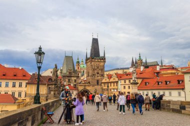 Prag, Çek Cumhuriyeti - 24 Mart 2023: Çek Cumhuriyeti 'nin Prag kentindeki ünlü Charles köprüsünde yürüyen turistler
