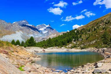 İsviçre 'nin Zermatt kentindeki Five Lakes Trail' de yaz mevsiminde Grunsee Gölü (Yeşil Göl) ve İsviçre Alpleri manzarası